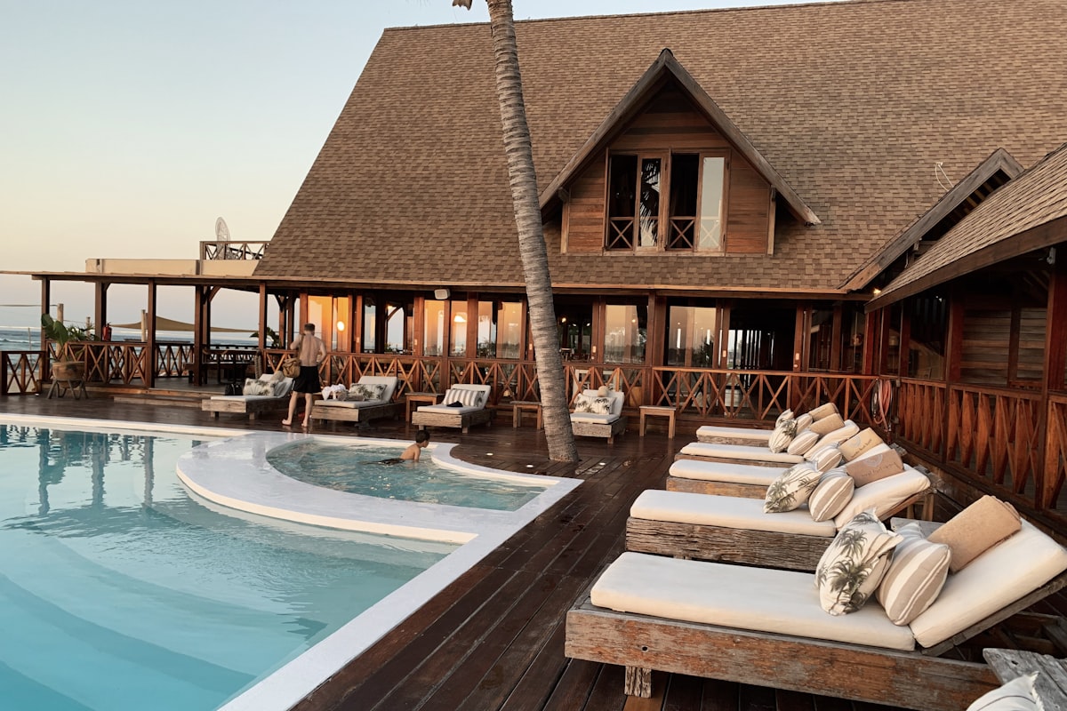 Luxury resort swimming pool surrounded by palm trees at dusk